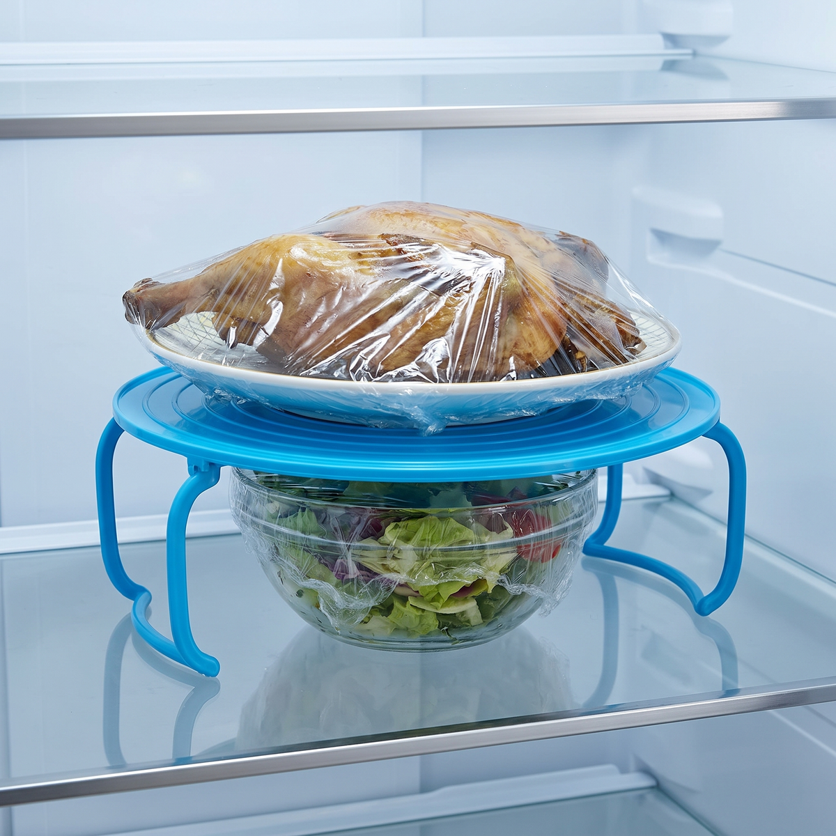 Support pliable 2 étages bleu dans un réfrigérateur avec un plat et un saladier