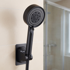 Pommeau de douche noir accroché à son support mural dans une salle de bain