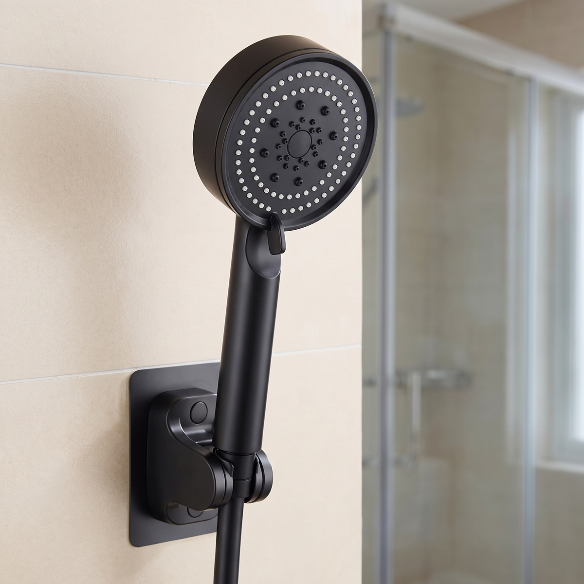 Pommeau de douche noir accroché à son support mural dans une salle de bain